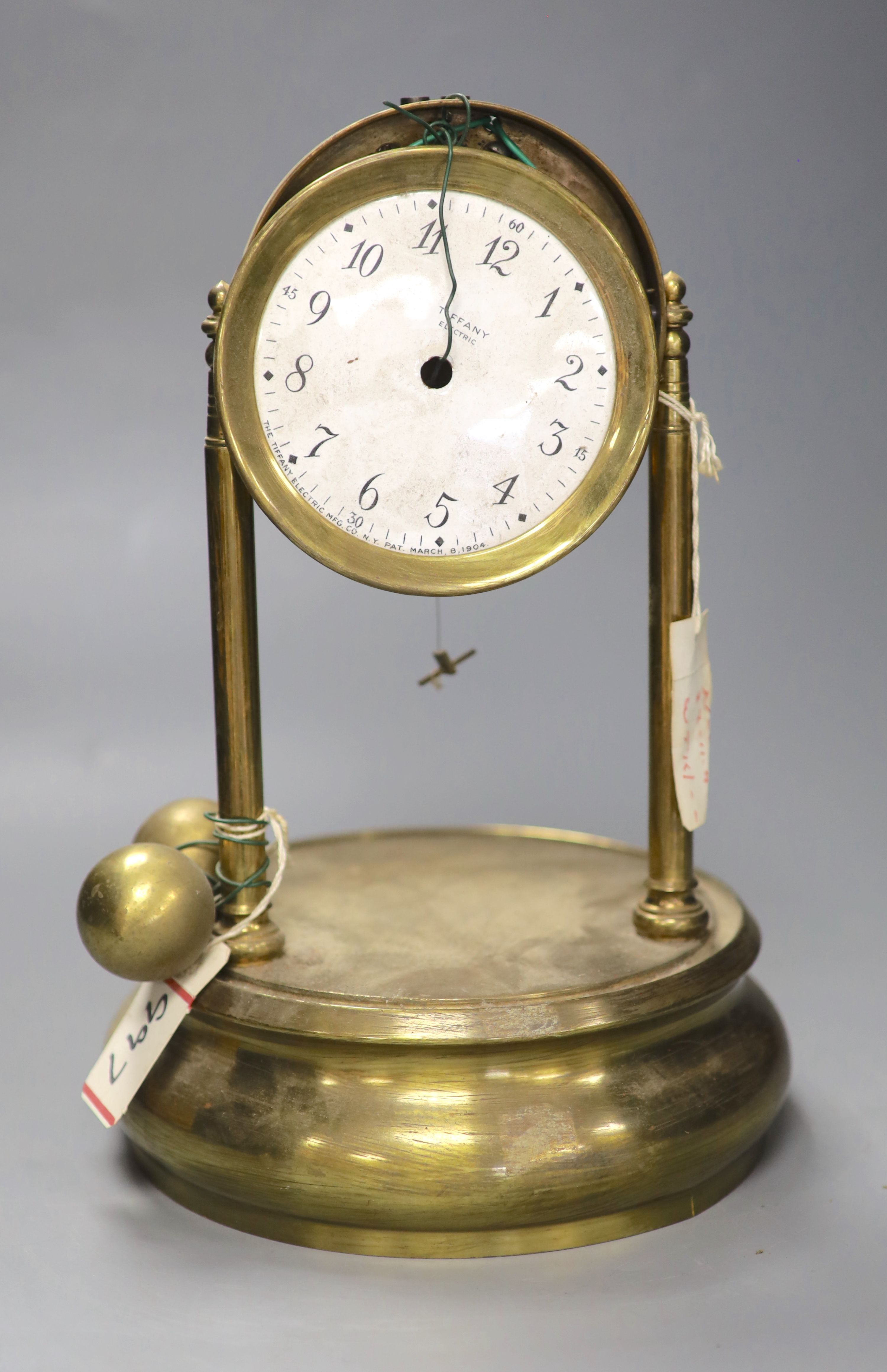 A Tiffany brass never wind electric clock, under glass dome, missing many parts